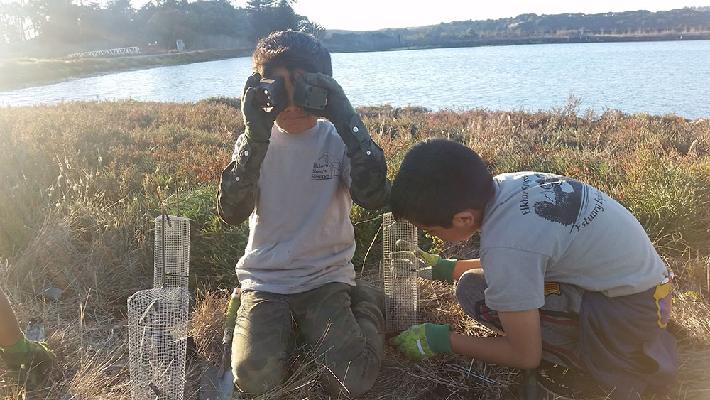 Two boys planting whistletop at the Elkhorn Slough estuary